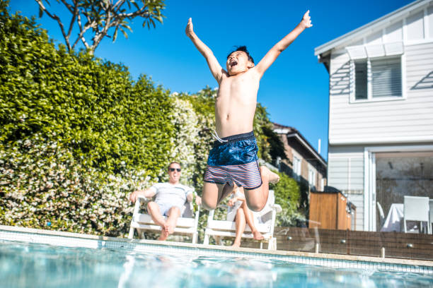 istock Boy jumping in the swimming pol 903002972