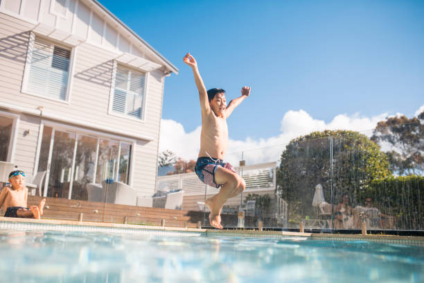 istock Boy jumping in the swimming pol 903002988