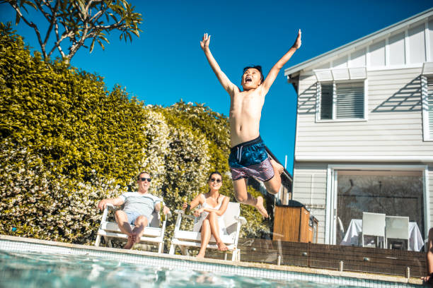 istock Boy jumping in the swimming pol 903002990