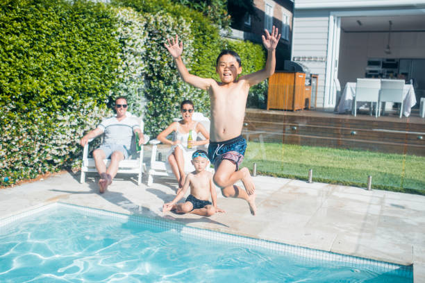 istock Boy jumping in the swimming pol 903003002