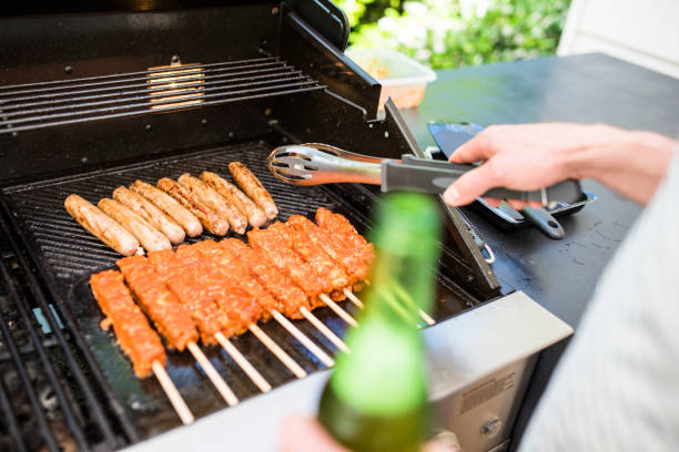 istock Man drinking beer and grilling meat on the barbecue 903003378