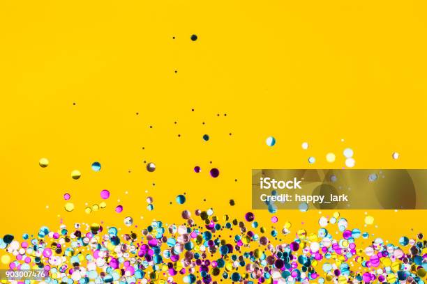 Colorido Confeti Sobre Fondo Amarillo Foto de stock y más banco de imágenes de Confeti - Confeti, Rebajas, Celebración - Ocasión especial