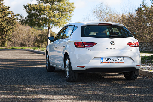 MALAGA, SPAIN - DECEMBER 2017:  White Seat Leon stays parked among clouds on road of Crete island. Seat Leon is a compact hatchback derived from the Seat.