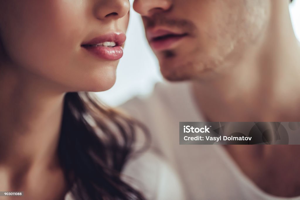 Couple in bedroom. Cropped image of beautiful young couple. Close up of two lovers are going to kiss. Couple - Relationship Stock Photo