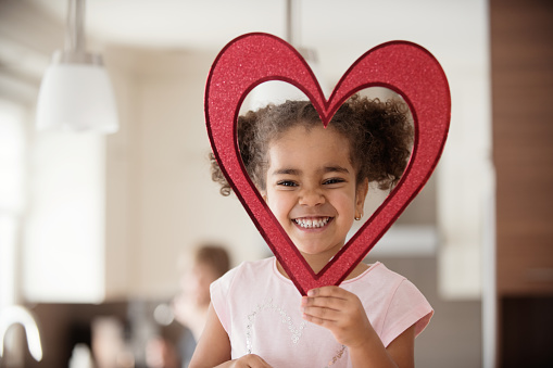 Celebrating love at Valentine's day with parents, family multi-ethnic of all ages and mixed race couple. Using heart shapes and cooking cupcakes and cookies with candies and decoration. Photos was taken in Quebec Canada.