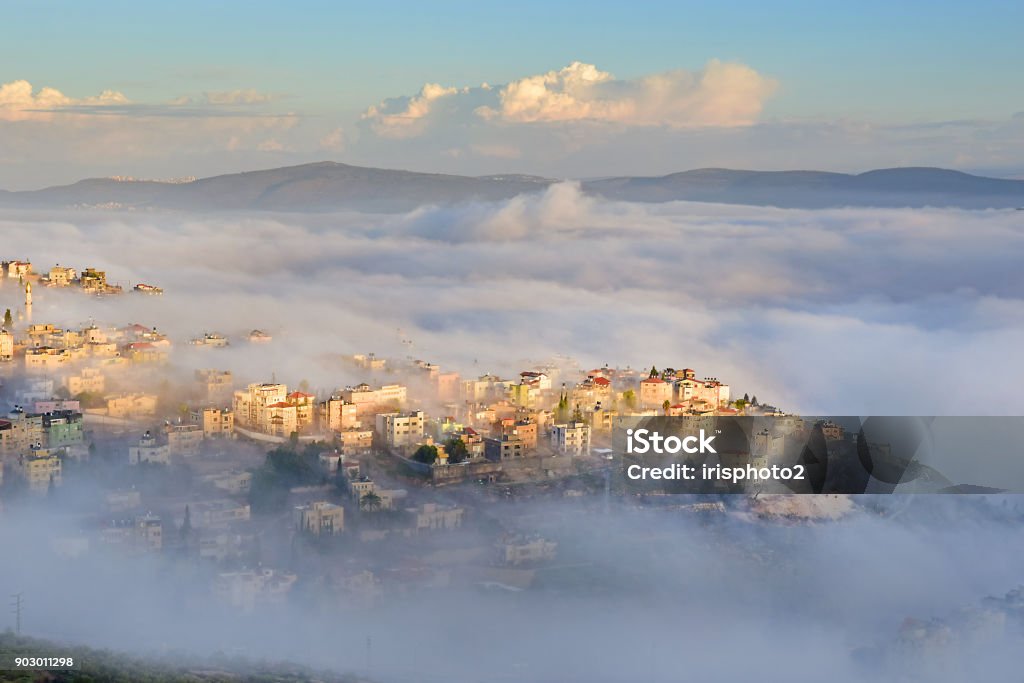 biblical village Cana of Galilee ( Kafr Kanna ) in morning fog, Nazareth in Israel view of the shrouded in the morning fog biblical village Cana of Galilee ( Kafr Kanna ), neighborhood Nazareth in Israel, place where Jesus Christ showed first miracle Galilee Stock Photo