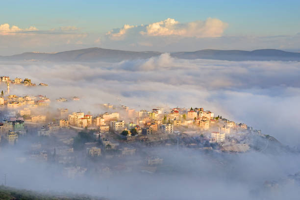 biblical village Cana of Galilee ( Kafr Kanna ) in morning fog, Nazareth in Israel view of the shrouded in the morning fog biblical village Cana of Galilee ( Kafr Kanna ), neighborhood Nazareth in Israel, place where Jesus Christ showed first miracle galilee photos stock pictures, royalty-free photos & images