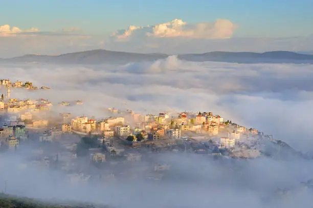 view of the shrouded in the morning fog biblical village Cana of Galilee ( Kafr Kanna ), neighborhood Nazareth in Israel, place where Jesus Christ showed first miracle