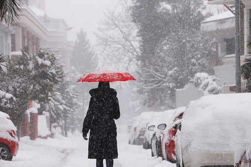 women walking in the street with red umbrella