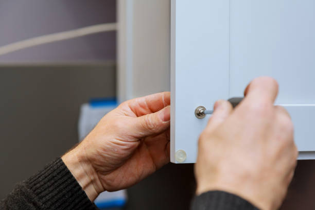 istock Hand on handle installation door in kitchen cabinet with a screwdriver 903012730
