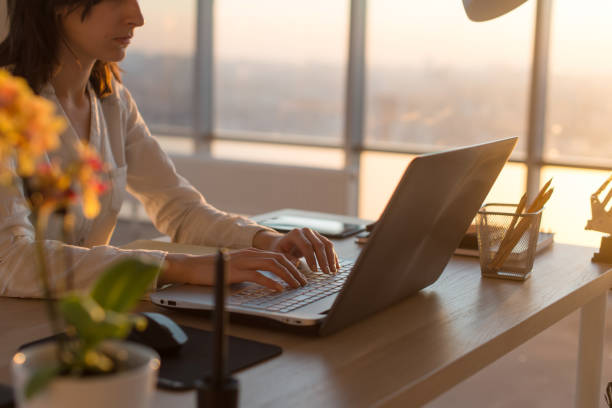istock Concentrated female employee typing at workplace using computer. Side view portrait of a copywriter working on pc home. 903016362