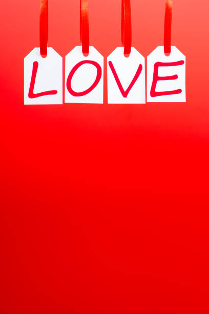istock Love word is written in the white tags on the red background. 903023628