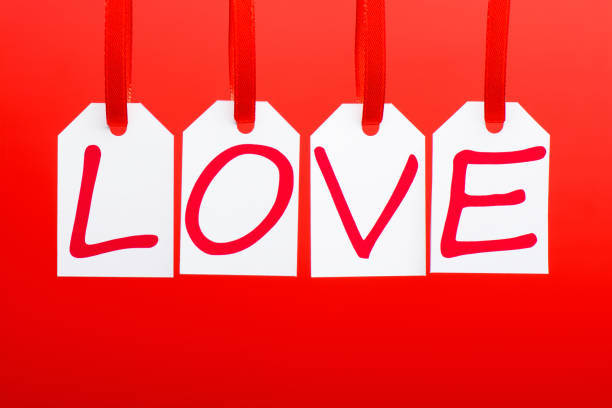 istock Love word is written in the white tags on the red background. 903023644