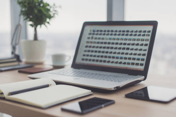 Sideview of office desktop with blank laptop and various tools