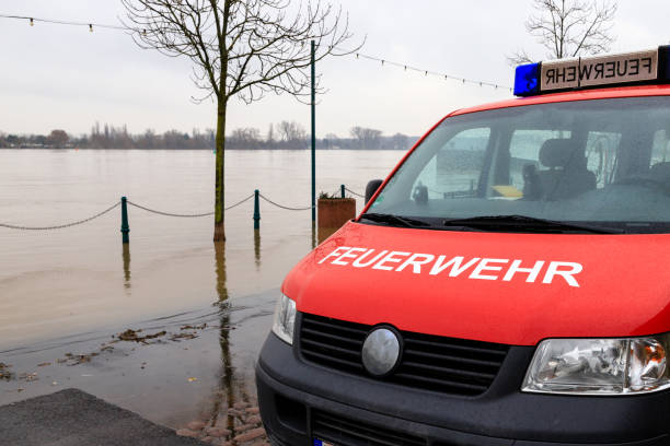 Fire department car on the flooded shore of a river Fire department car on the flooded shore of a river. nierstein stock pictures, royalty-free photos & images