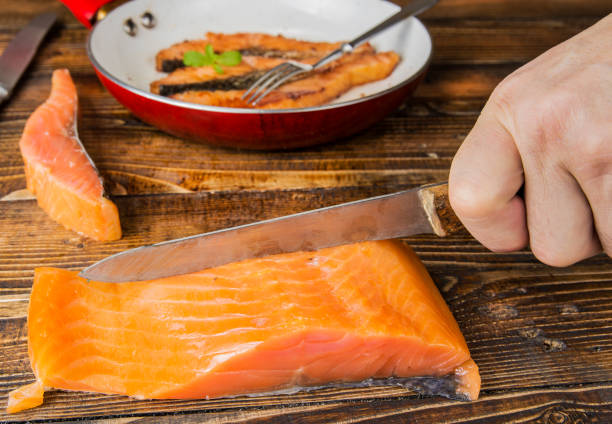 istock Fried salmon fillets on the pan on the wood 903031368
