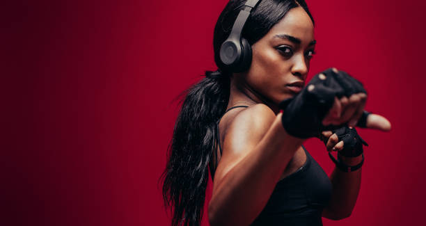 silna młoda kobieta ćwiczy boks - fighting stance zdjęcia i obrazy z banku zdjęć