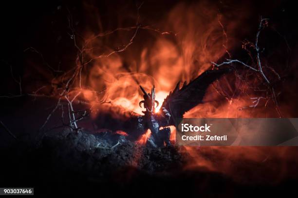 Silhouette Of Fire Breathing Dragon With Big Wings On A Dark Orange Background Horror Image Stock Photo - Download Image Now