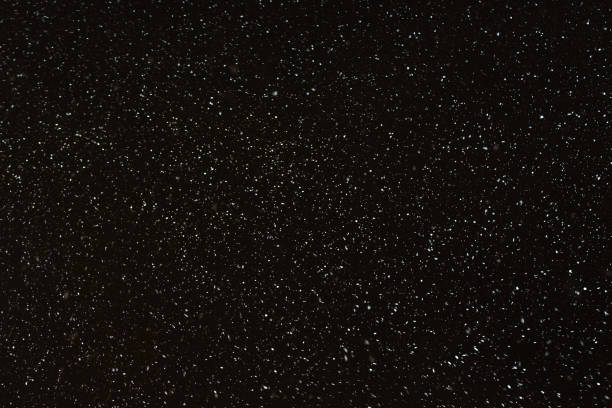 istock Abstract winter night background - snowflakes on a dark sky 903041394