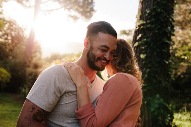 istock Handsome young man embracing his girlfriend in a park 903044172