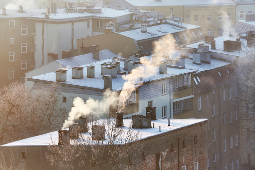 Smoking chimneys in Szczecin city at sunrise indicate burning of wood and coal in old home heating systems. Residents in many Polish cities complain of increasing health problems due to air pollution.