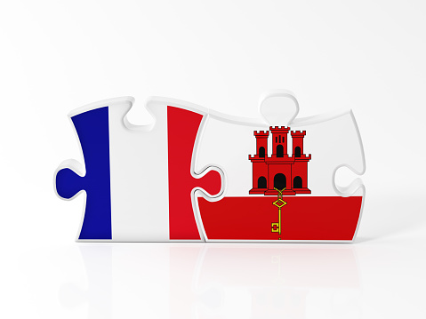 Jigsaw puzzle pieces textured with French and Gibraltar flags on white. Horizontal composition with copy space. Clipping path is included.