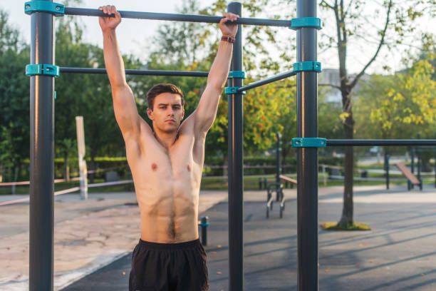 istock Fitnes man hanging on wall bars. Core cross training working out abs muscles 903049294
