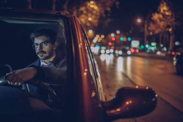 istock Businessman driving car at night 903049506
