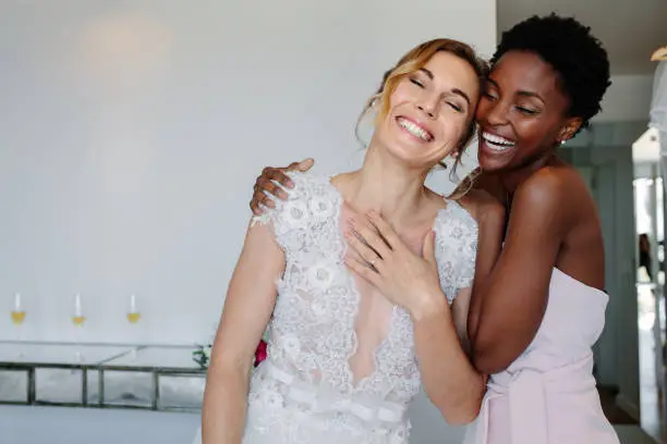 Photo of Cheerful bride and bridesmaid on the wedding day