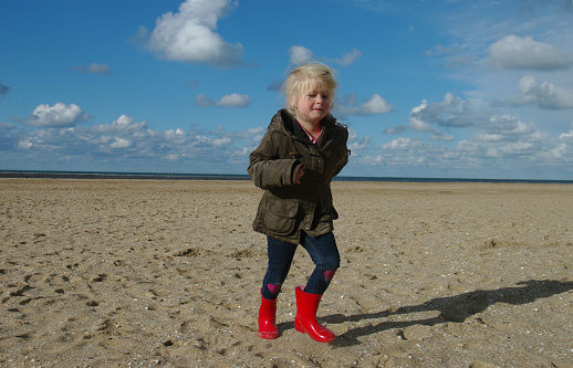 Little girl looking for Shells on the Normandy Beach