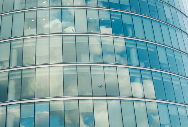 istock Modern glass building and airplane reflection 903062058