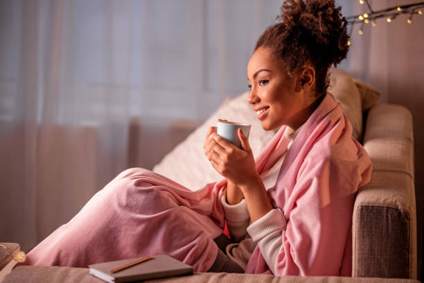 istock Cheerful african woman drinking beverage in apartment 903062262
