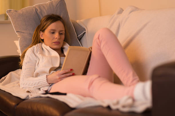 istock Relaxed woman reading book at home. 903065794