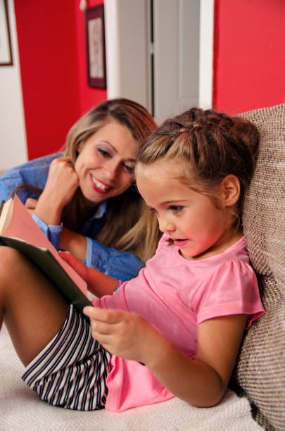 istock Cute 5 year old girl reading book 903074060