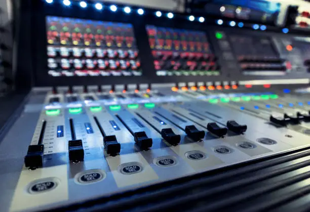 Photo of control panel of the sound engineer with the mixers on the television studio