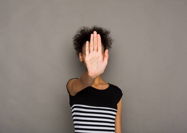 istock Young woman covering her face with palm 903085542