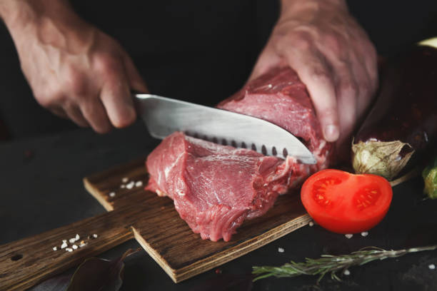 istock Chef cutting filet mignon on wooden board at restaurant kitchen 903088224