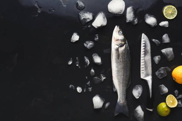 istock Fresh sea bass with ice at black background 903089164