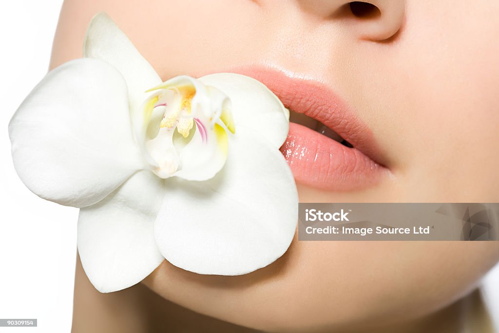Frau mit Orchidee im Mund - Lizenzfrei Attraktive Frau Stock-Foto