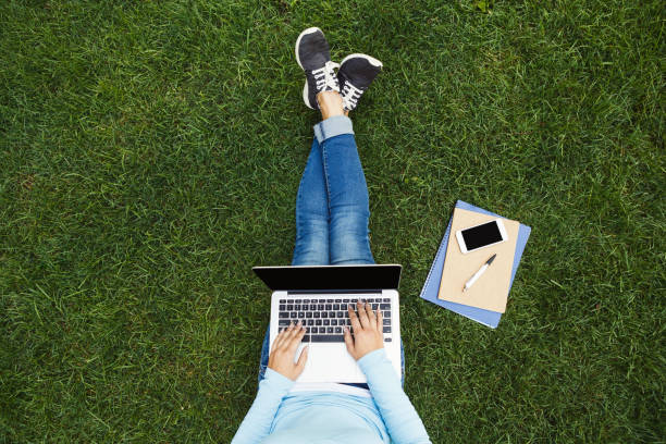 istock Girl with laptop on the grass 903092518