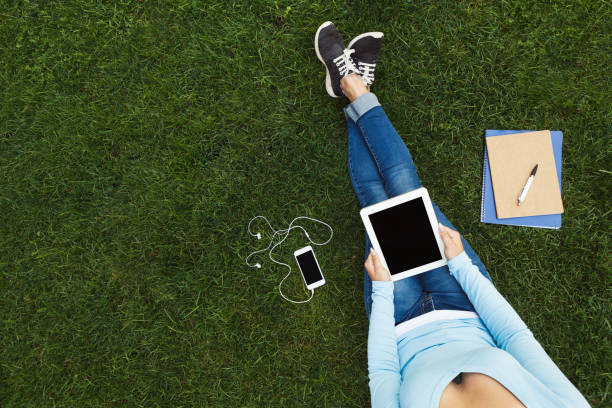 istock Girl with digital tablet on the grass 903092756