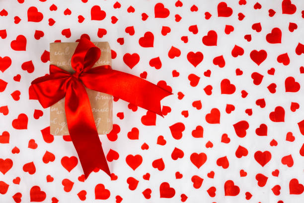 istock Valentine's Day. Presented as a red ribbon on a white paper with red hearts 903097582