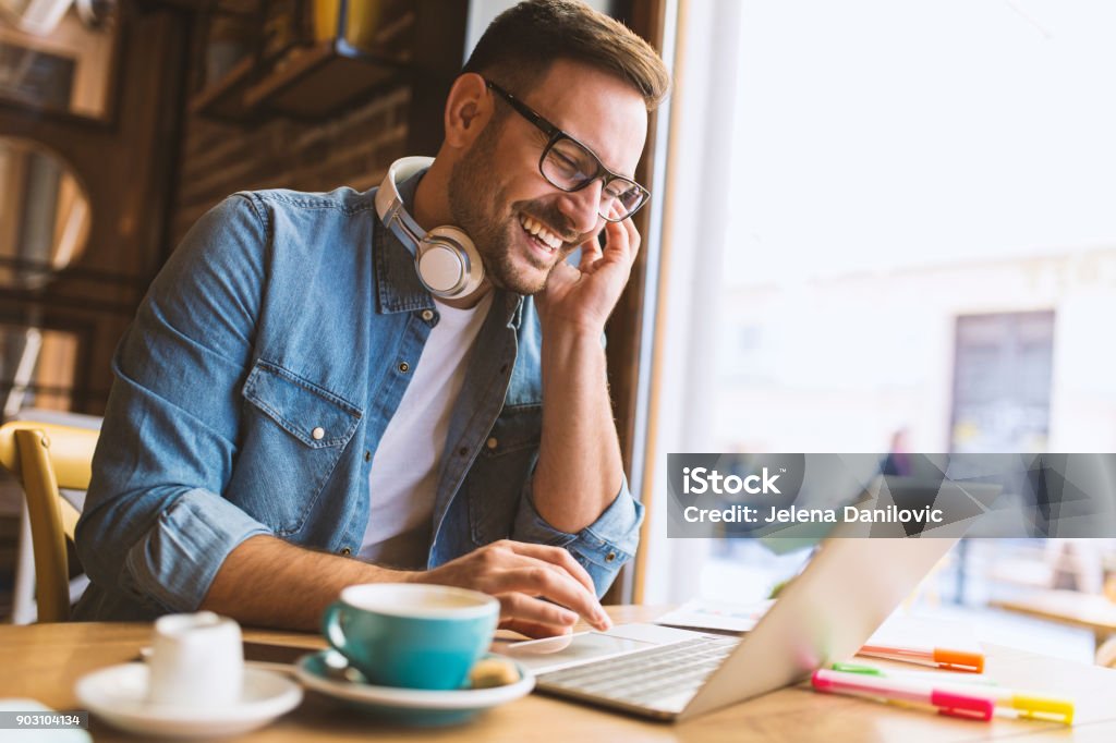 Freelance Handsome man working remotely from the coffeehouse Men Stock Photo