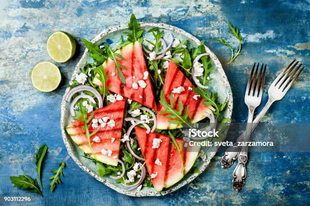 Fresh Summer Grilled Watermelon Salad With Feta Cheese Arugula Onions On Blue Background Stock Photo - Download Image Now