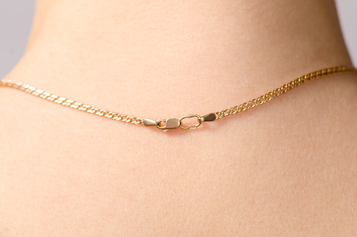 Clasp of a gold chain on the neck beauty macro
