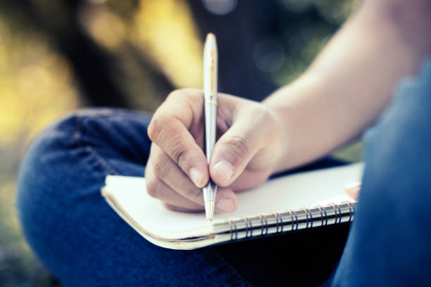 istock close up young women writing on notebook in park, concept in education and knowledge 903116554