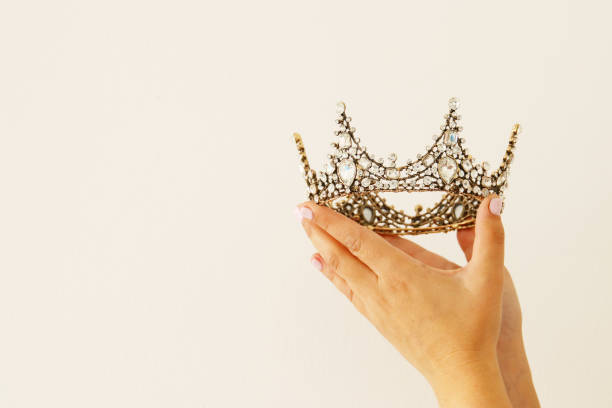 istock Woman's hand holding a crown for show victory or winning first place. White background. Copy space. Isolated. 903120286