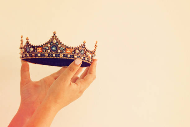 istock Woman's hand holding a crown for show victory or winning first place. White background. Copy space. Isolated. 903120304