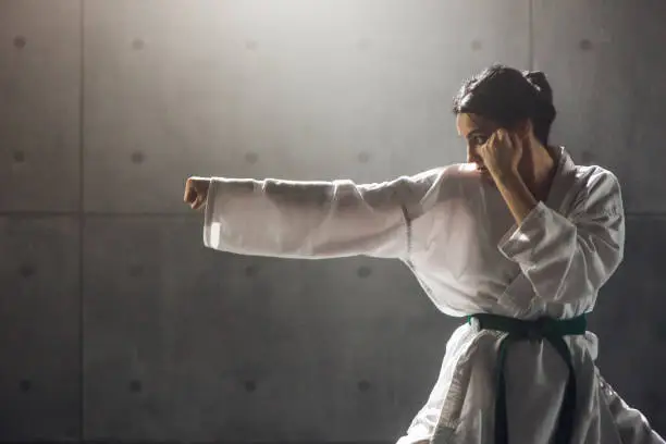 Martial arts Concept. Young woman in kimono practicing karate