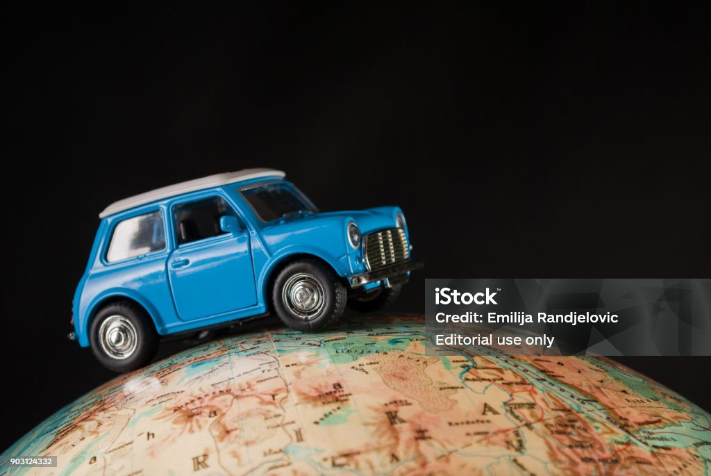 Miniature Figure Toy Car Mini Morris On Geographical Globe Of
